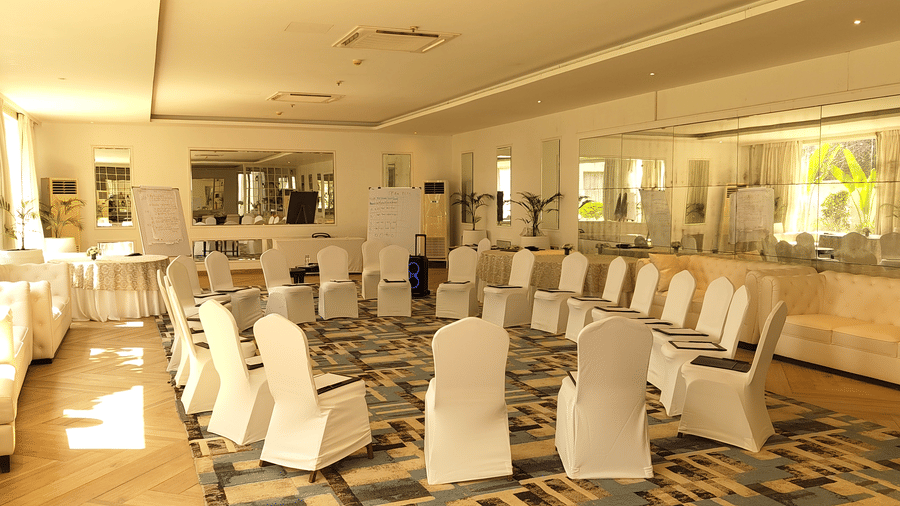  The Mansion House resort banquet room with long table, white-covered chairs, plates, glasses, and napkins, brightly lit and arranged for a formal gathering.