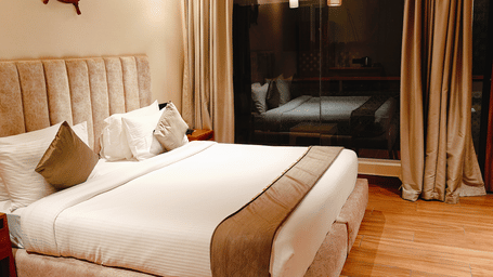 A comfortable bedroom at Smith Balcony Villa with a plush bed, large curtains, and warm lighting