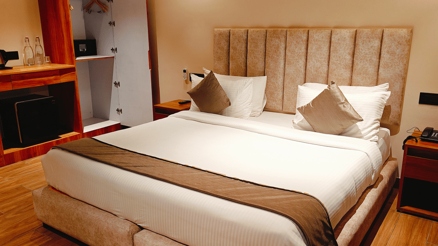 A stylish bedroom at Smith Balcony Villa featuring a double bed, side tables, and a compact kitchenette setup