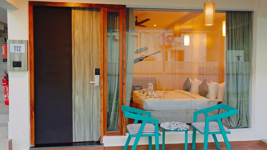 An outdoor seating area at Ross Villa with patio chairs and access to the bedroom through glass doors