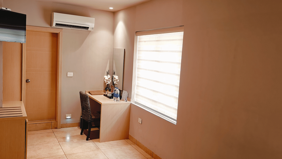 Spacious layout of the Business Class Room at Chola Dynasty, Kumbakonam featuring modern furnishings, a window allowing natural light, and thoughtfully arranged interiors for a pleasant stay.