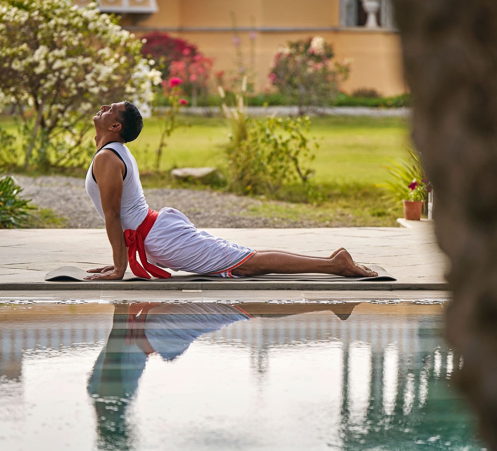 image of a man doing yoga at the poolside at dev shree, deogarh