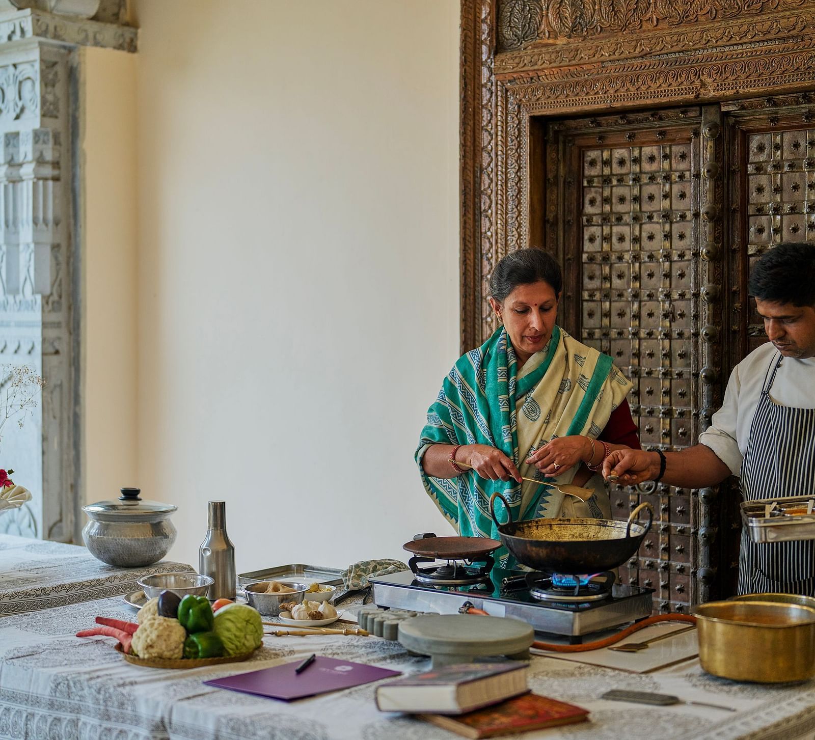 an image of a woman taking culinary classes at Dev Shree, Deogarh along with a trained chef