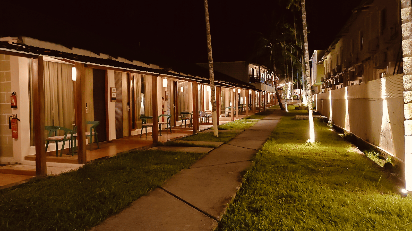 A walkway at Arina Island Resort lined with warmly lit villas at night
