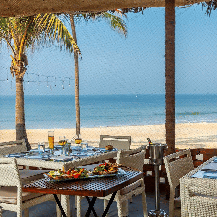 al fresco seating arrangements in a shack with the sea in the background - Caravela Beach Resort Goa