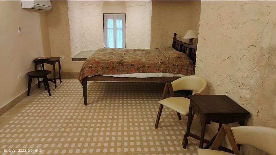 Room with bed, patterned floor, window, tables, and chairs - Tijara Fort-Palace - 19th Century, Alwar.