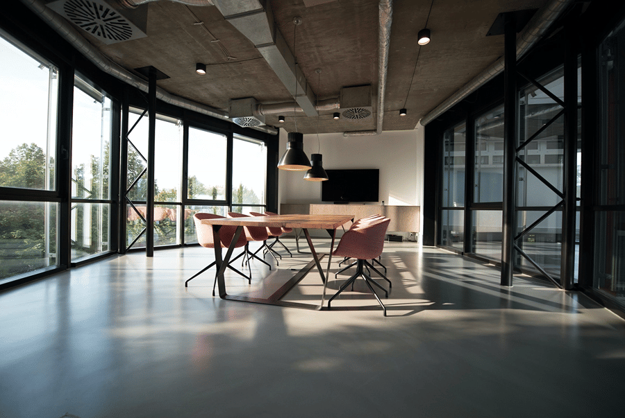 Modern conference room with large glass windows, a long table with chairs and a TV screen