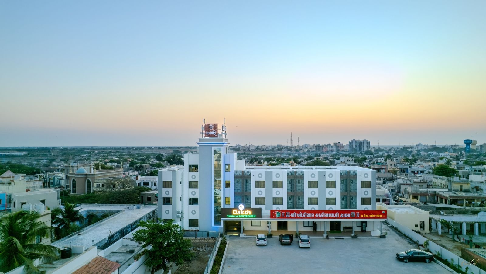 Expansive aerial view of Daksh The Grand Gowardhan, Dwarka, at dusk, revealing its impressive scale amidst the surrounding landscape.