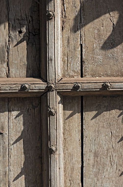 A close up shot of a wooden door with nails on it - MANVAR Resort & Desert Camp