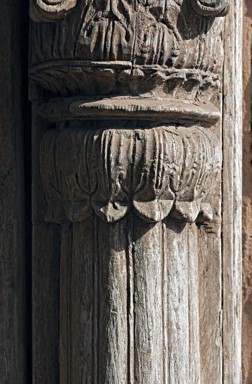 A close up shot of a pillar with intricate carving on it