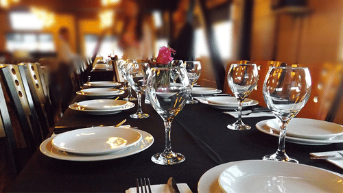 a table with cutlery and glasses and black cloth on the table
