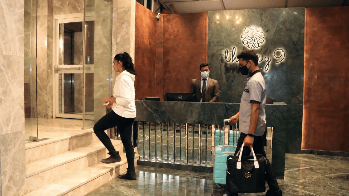 Guests checking in at hotel reception desk with elegant interior decor