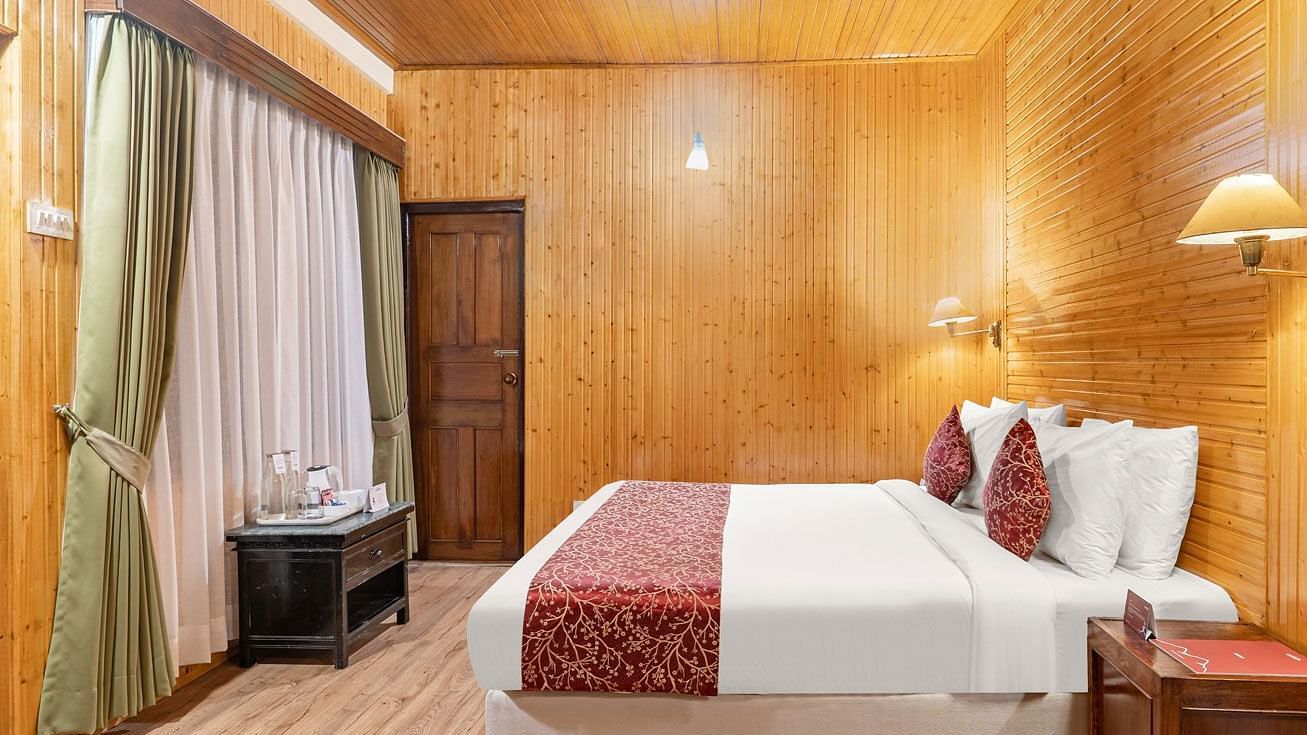 Side view of a room with bed and a table besides it at Summit Tashi Ghang Heritage Resort, Pelling