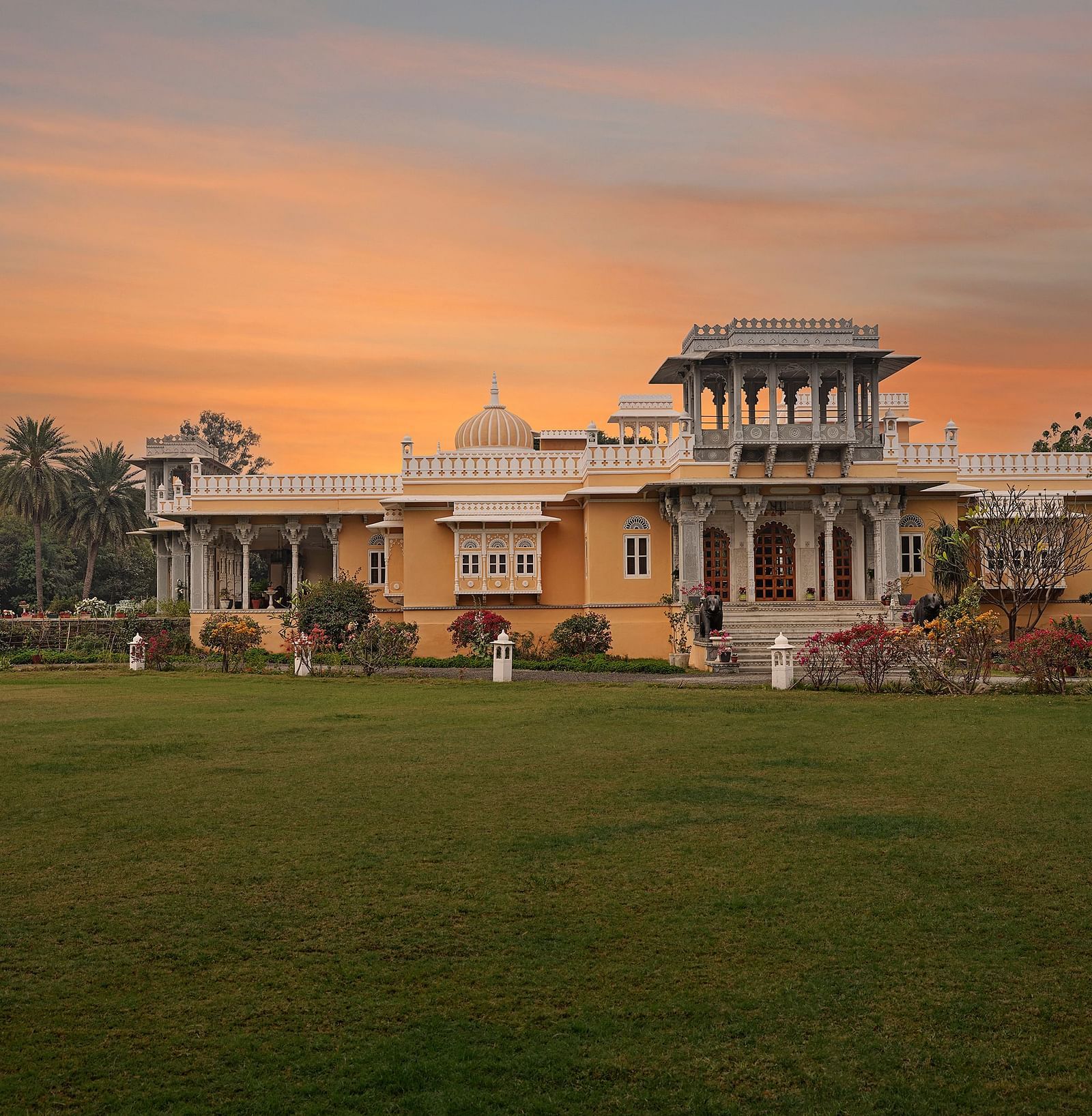 Facade image of dev shree, deogarh with a beautiful sunset sky with orange hues in the background