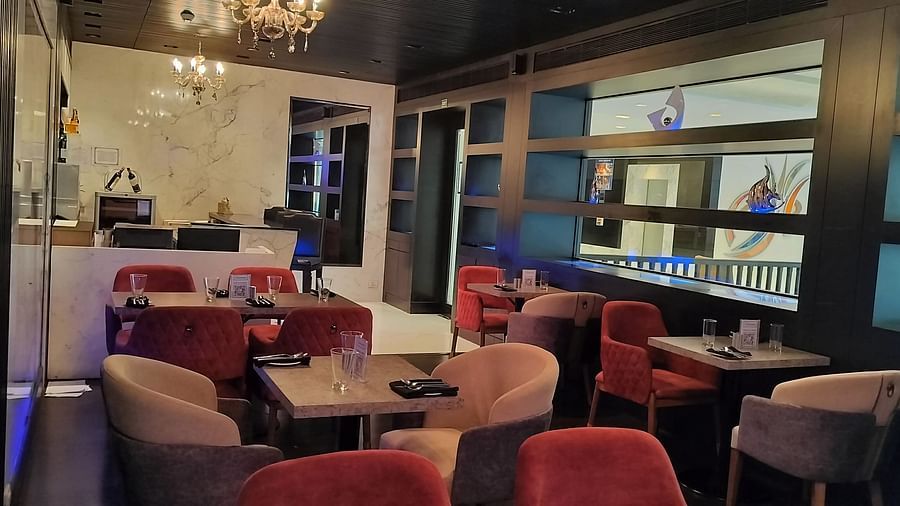  Café-style seating area with compact tables, decorative shelving, and open layout.