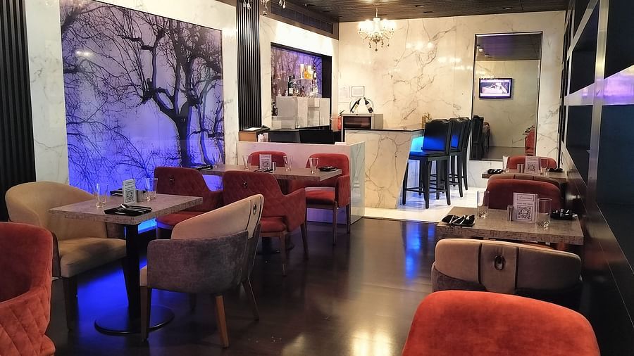 Stylish lounge area with armchairs, abstract wall art, and ambient ceiling lights.