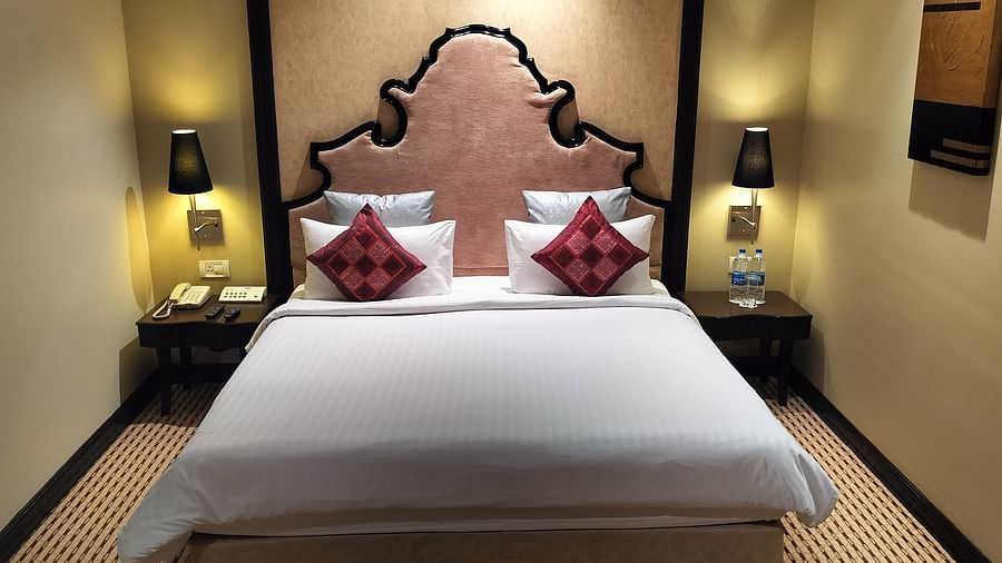  Cosy room with a single large bed, decorative headboard, side tables, and soft lighting.
