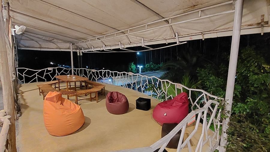Outdoor seating area at night with a mix of chairs and bean bags - Matsya Island Retreat by Island Quest.
