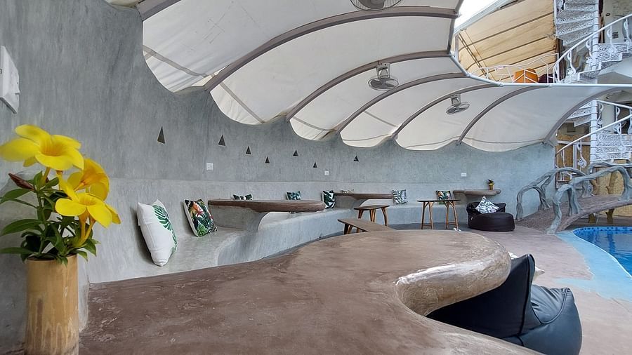 Modern poolside lounge with a stylish, curved roof - Matsya Island Retreat by Island Quest.