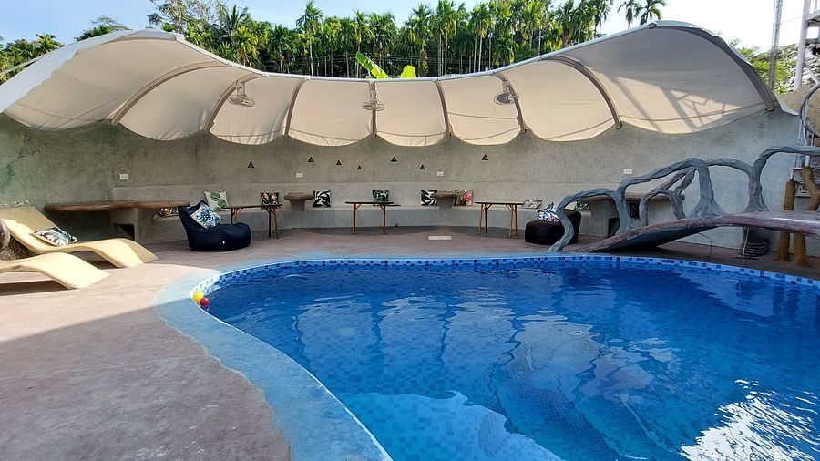 Serene poolside scene with comfortable seating and a tranquil ambiance -Matsya Island Retreat by Island Quest.