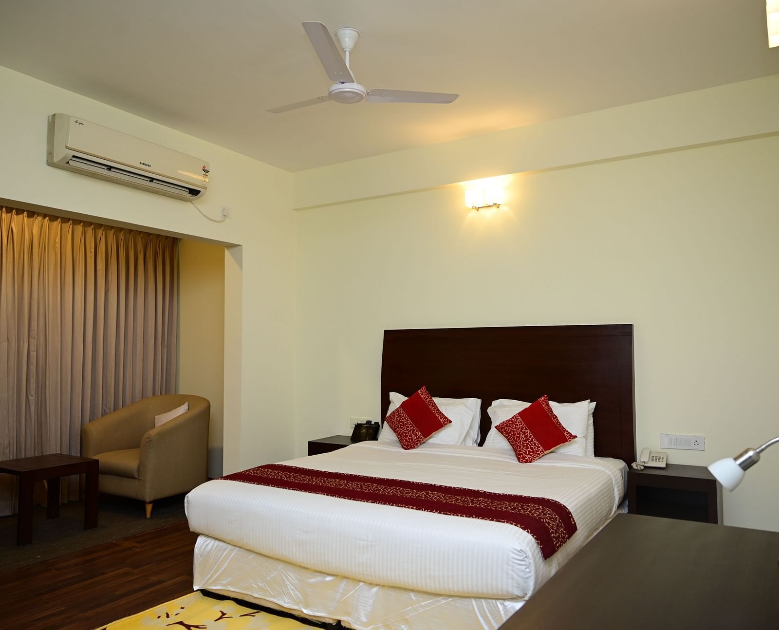 A double bed with red blanket and red pillow covers in the Executive Suite at Sterling Keys by TGI 4