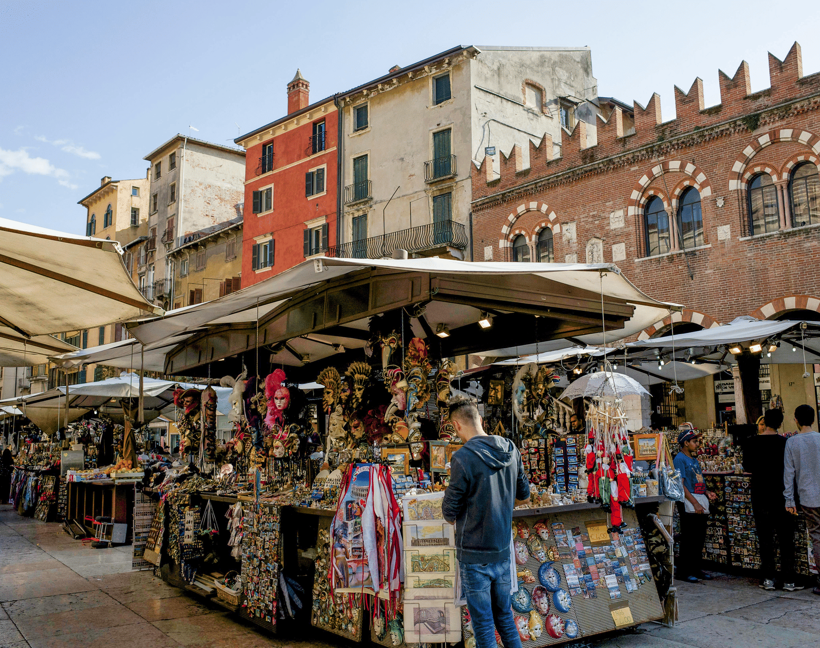 A street market selling several souvenir items on a bright day with a clear blue sky in the background