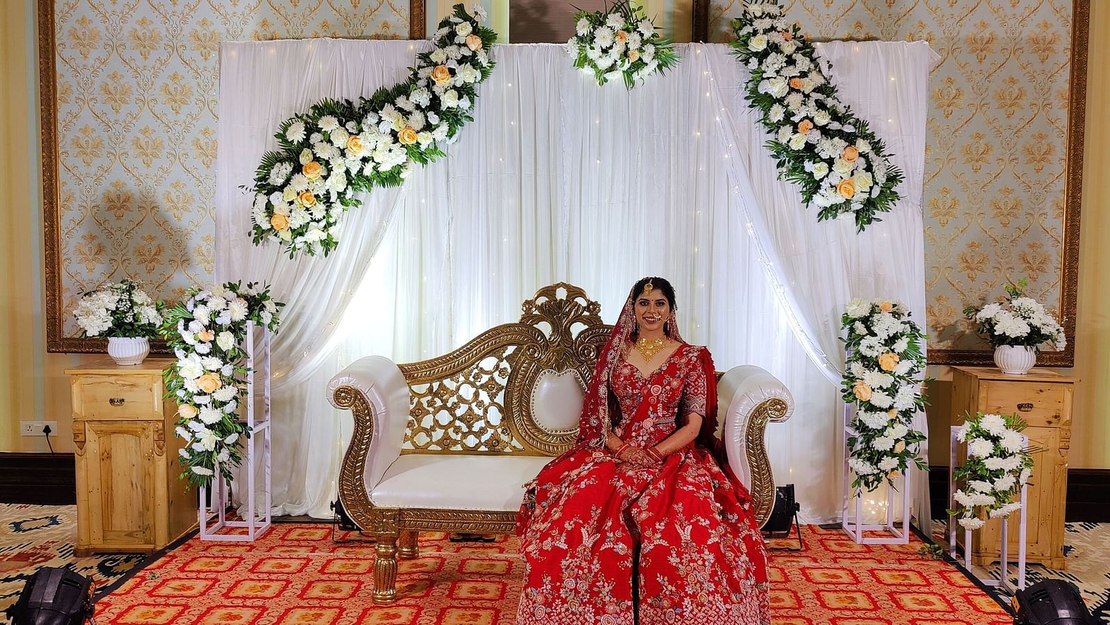Swosti Chilika Resort - image of a bride dressed in traditional Indian attire seated on a decorated couch inside the banquet hall jo2lkd