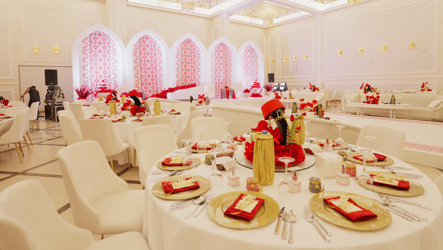 An elegantly decorated banquet hall at La Maison, Doha, with round tables set for a formal event.