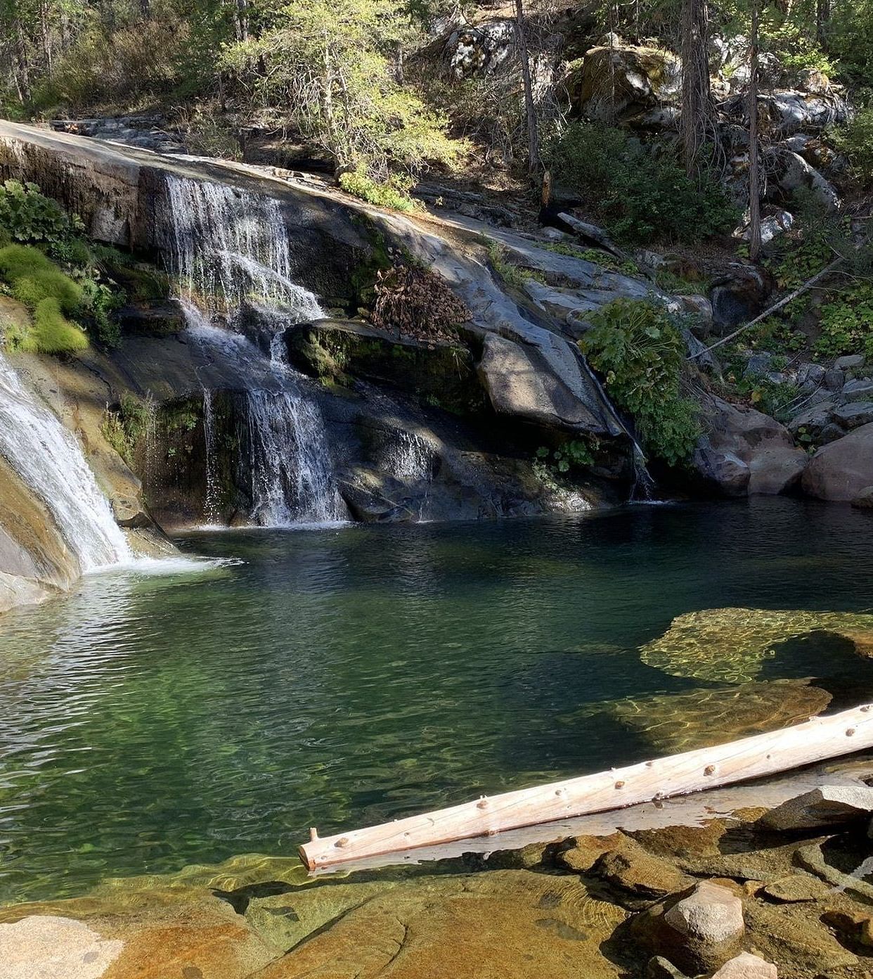 Image of Carlon Falls, showcasing cascading water flowing into a serene pond, surrounded by lush trees