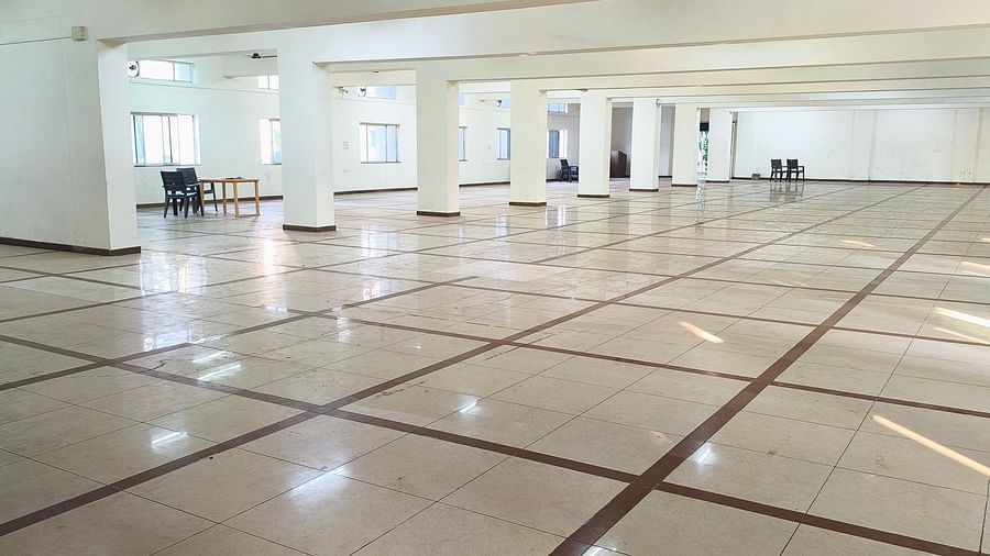 A long view of an expansive, empty hall at BNGV Grandeur Hotel and Banquets, revealing rows of pillars and a polished floor.