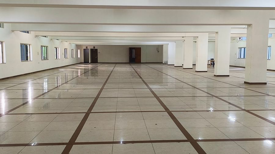 A large, empty hall at BNGV Grandeur Hotel and Banquets, characterised by its wide space and multiple windows lining the walls.