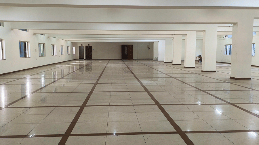 A large, empty hall at BNGV Grandeur Hotel and Banquets, characterised by its wide space and multiple windows lining the walls.