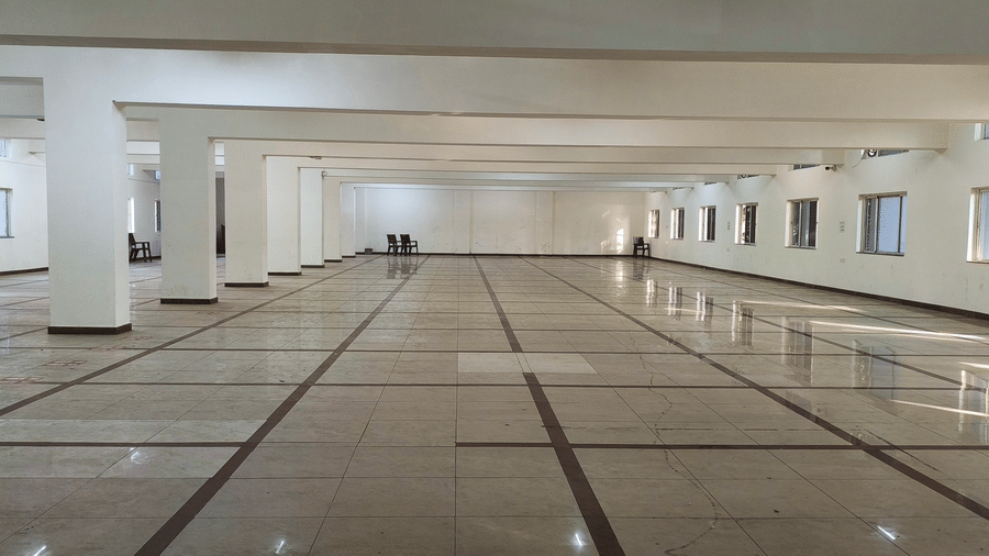 Another view of the expansive, empty event space at BNGV Grandeur Hotel and Banquets, featuring clean lines and a checkered floor.