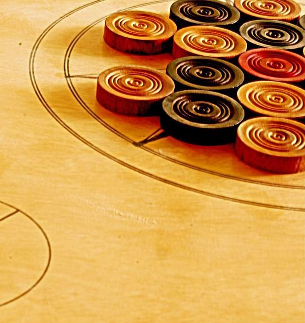 An image of carrom coins placed at a carrom board