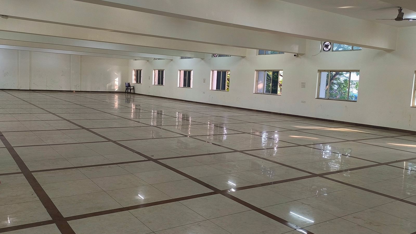 An expansive, vacant banquet hall at BNGV Grandeur Hotel and Banquets with a shiny floor, highlighting its potential for large gatherings.