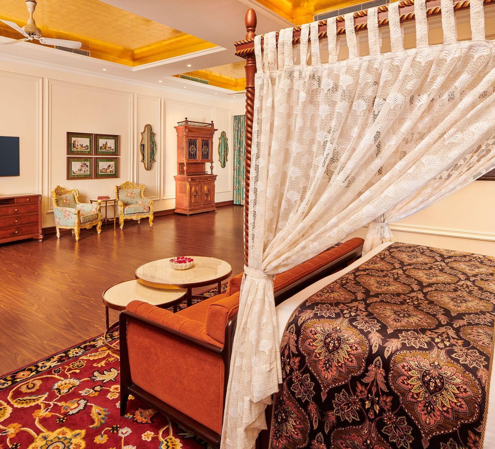 Luxurious suite with white canopy bed and spacious wooden flooring.