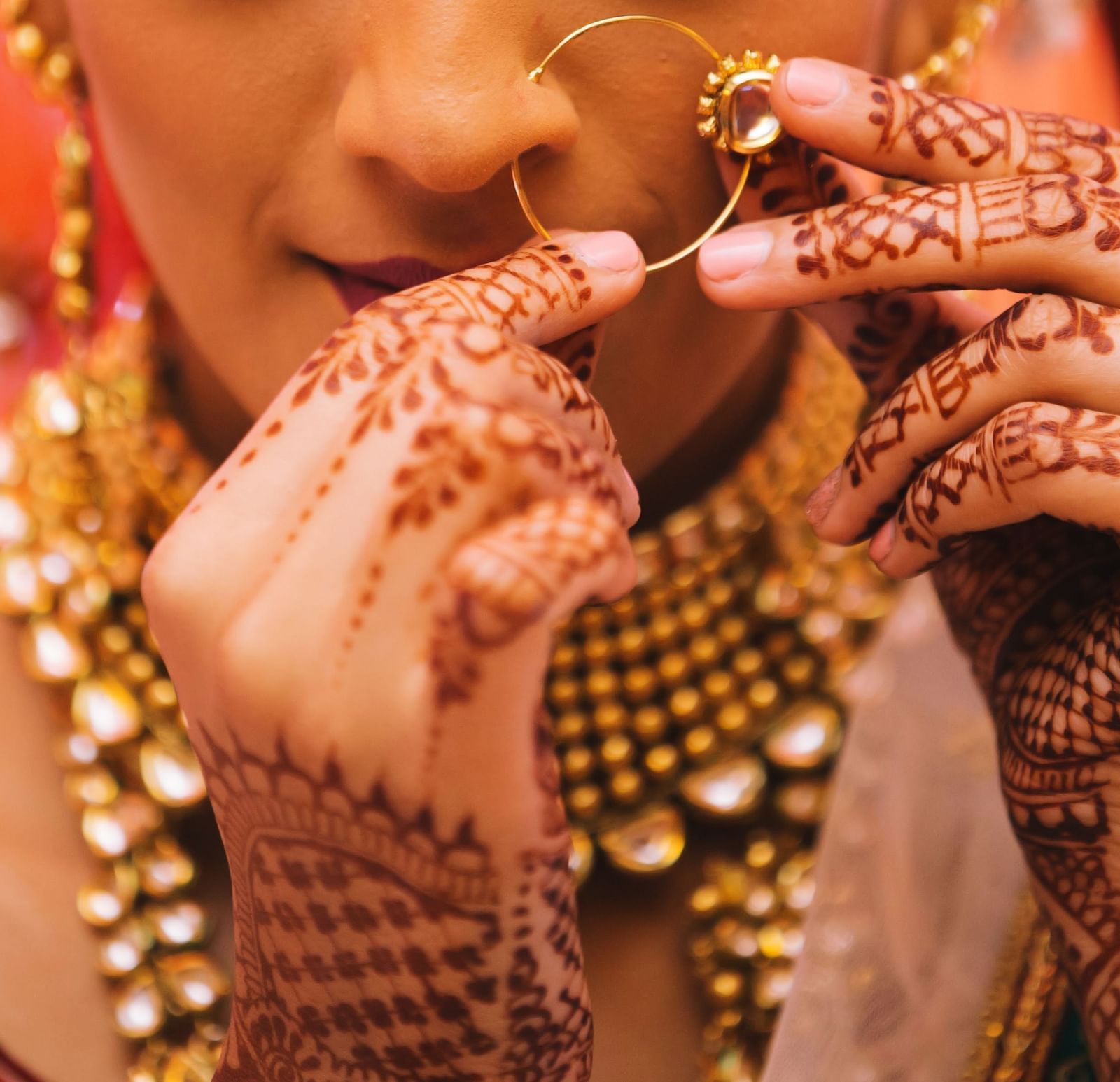 An image of a bride fixing her nose ring