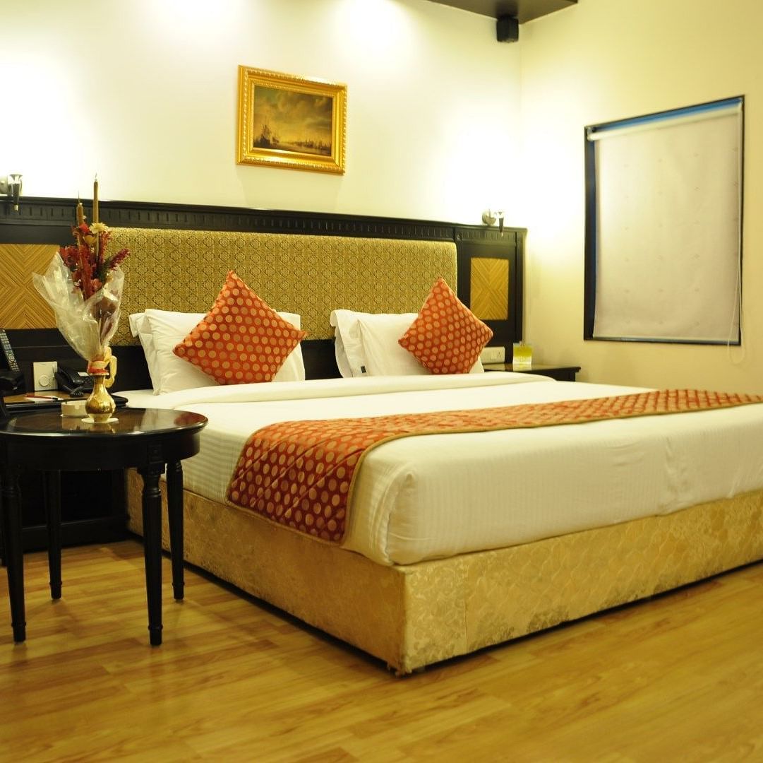 Royal Suites with comfortable bed and chairs at SRM Hotel Trichy
