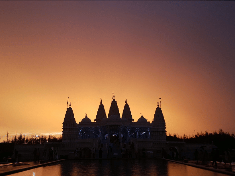 A silhouette of Surya Mandir with a serene sunset in the background