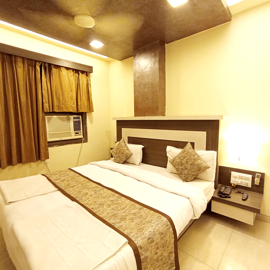 Cozy bedroom interior featuring a neatly made bed with a patterned runner and warm bedside lighting.