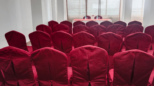 Interior of a hall with neatly arranged chairs and a table in the center