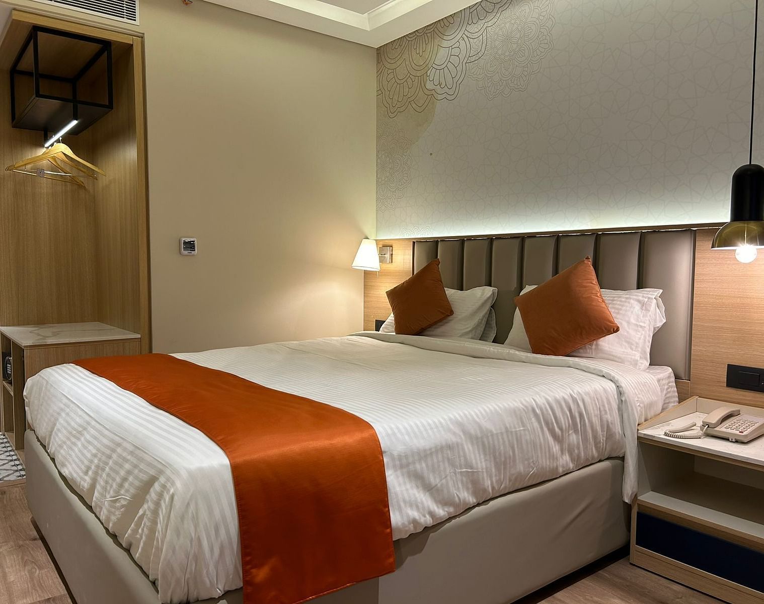 A cosy room with warm lighting, a bed, bedside tables, and lamps - TGI Oberon, Koramangala