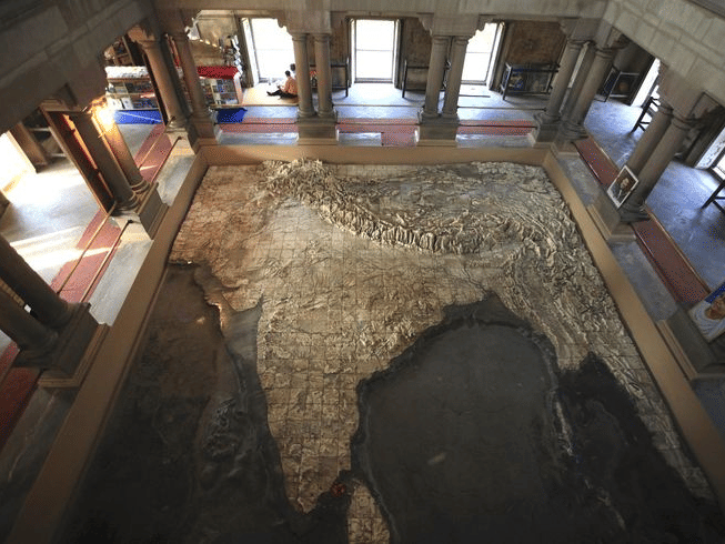 A high-angle view of a large relief map of India carved out of marble on the floor of a building | HHI Varanasi