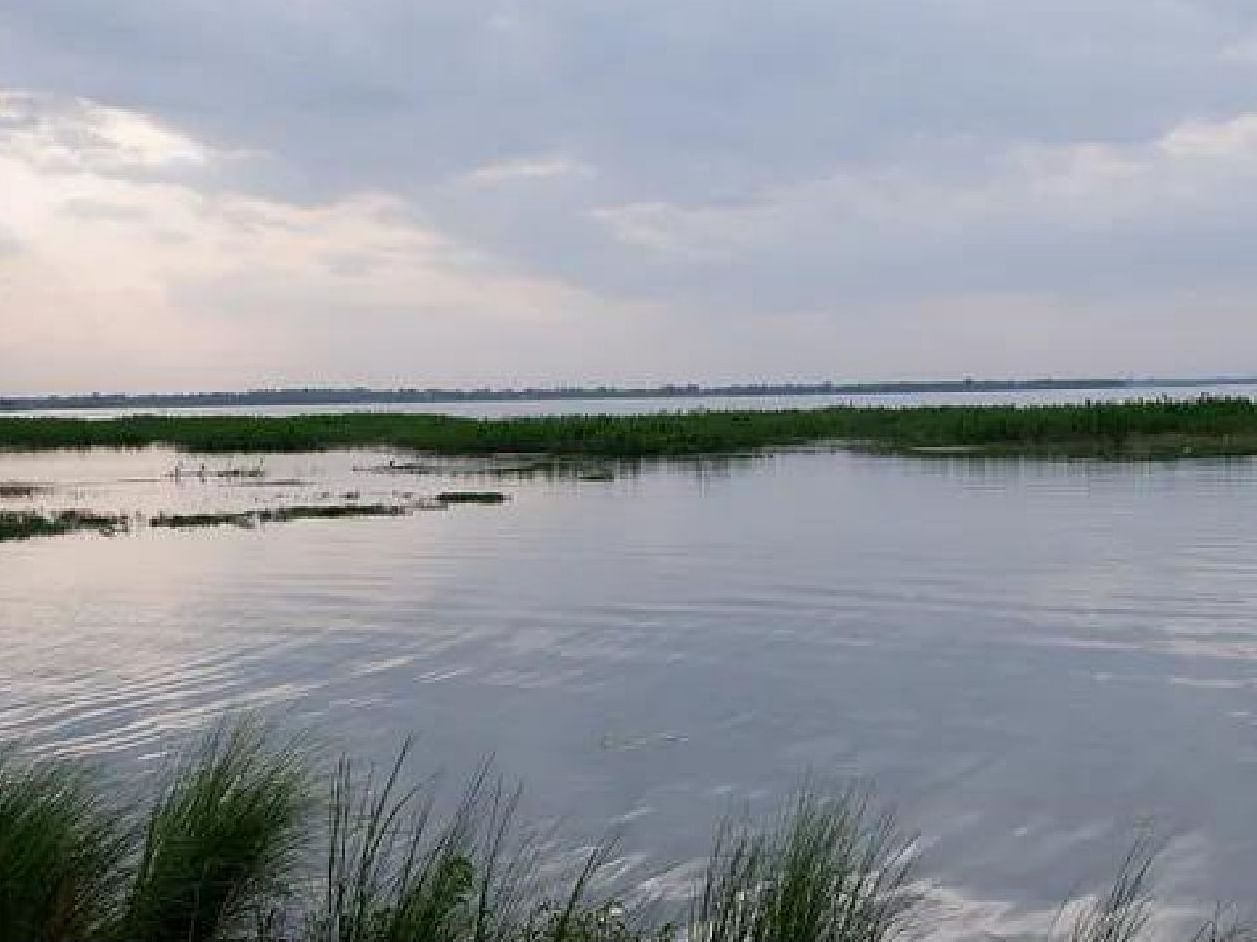 Veeranam Lake with tranquil waters, reflecting the vibrant hues of the sunset sky