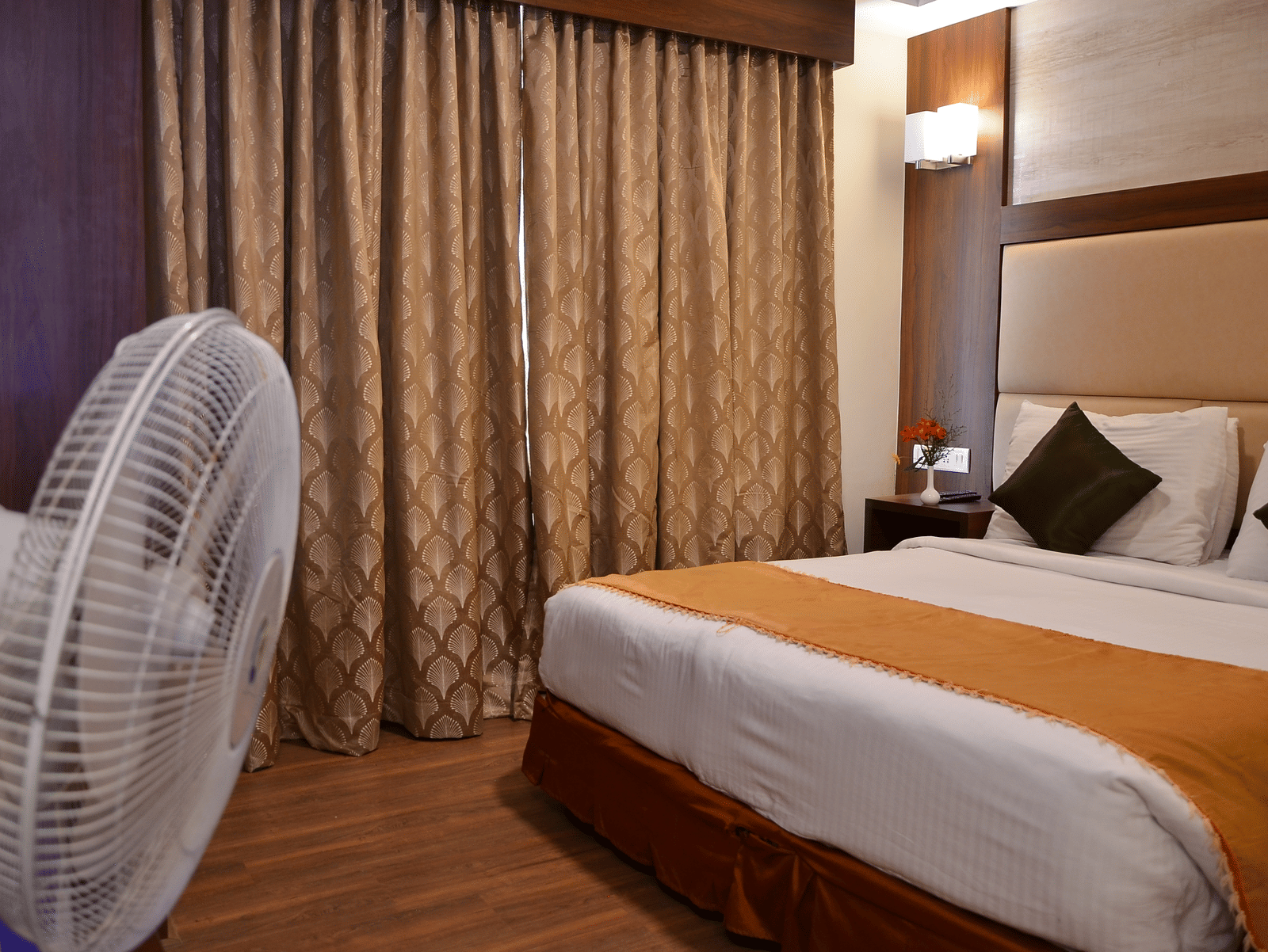 A neatly designed room with a single bed, curtain backdrop, and pedestal fan for added comfort - Benzz Park, Kodaikanal