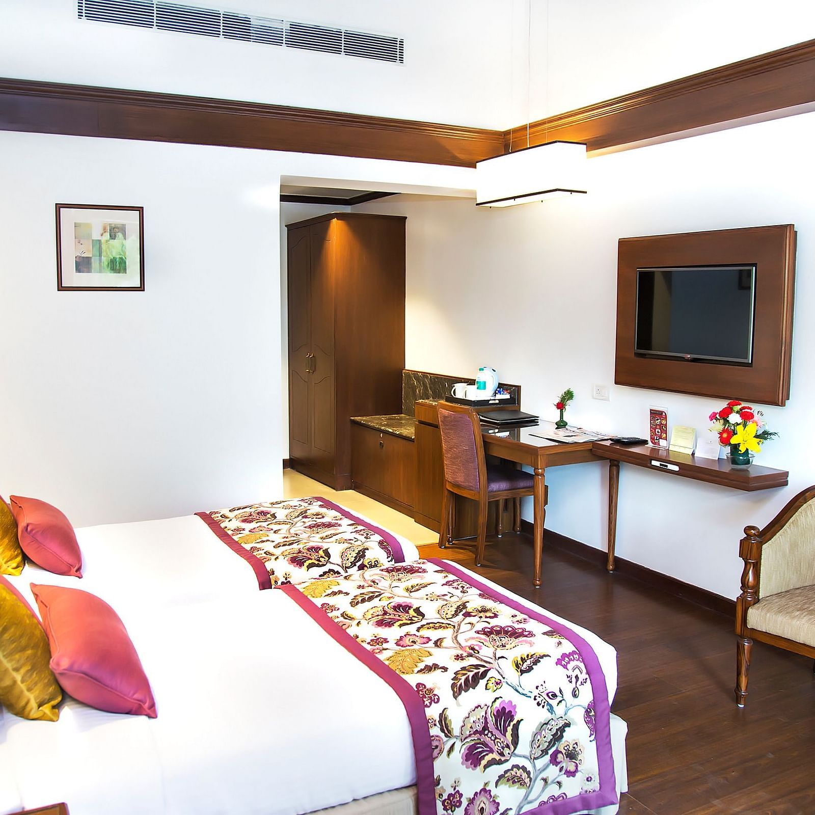 Image of a room with comfortable bed a chair tv side lamp and well decorated at Shervani Hilltop Nainital 