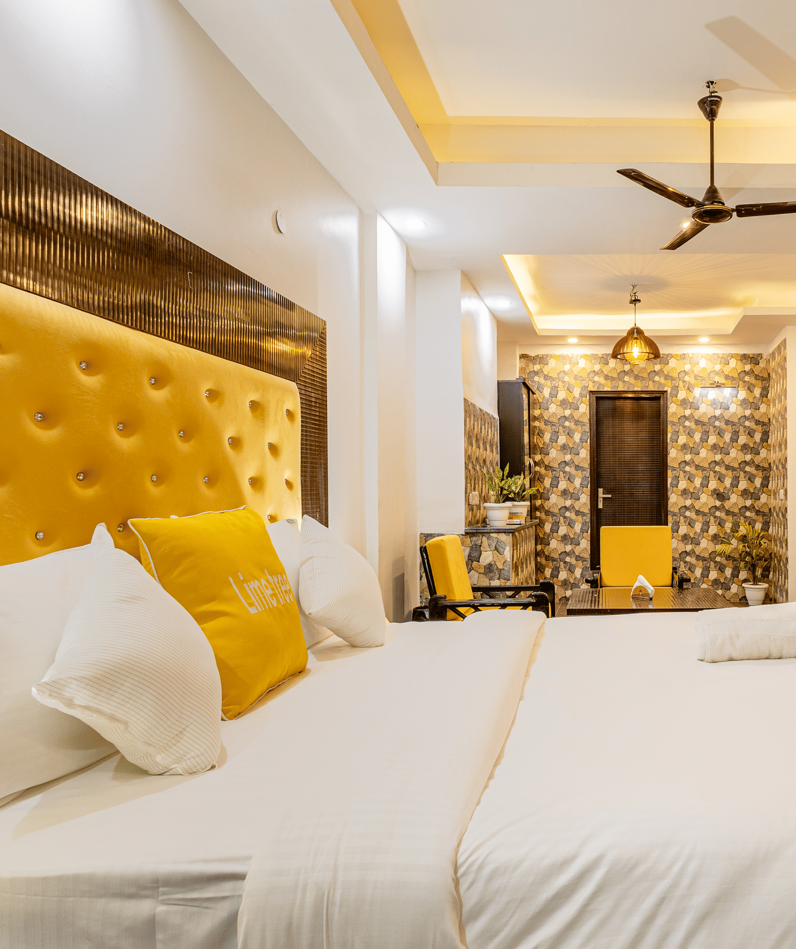 Side view of the king size bed and the living area in the Suite at Lime Tree Hotels and Banquet Hall Near Huda Metro, Gurgaon