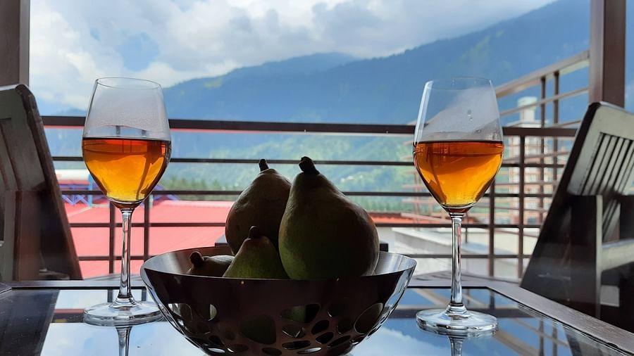 Seating area in the Premier Room's balcony with 2 wine glasses and a bowl of pears on the table