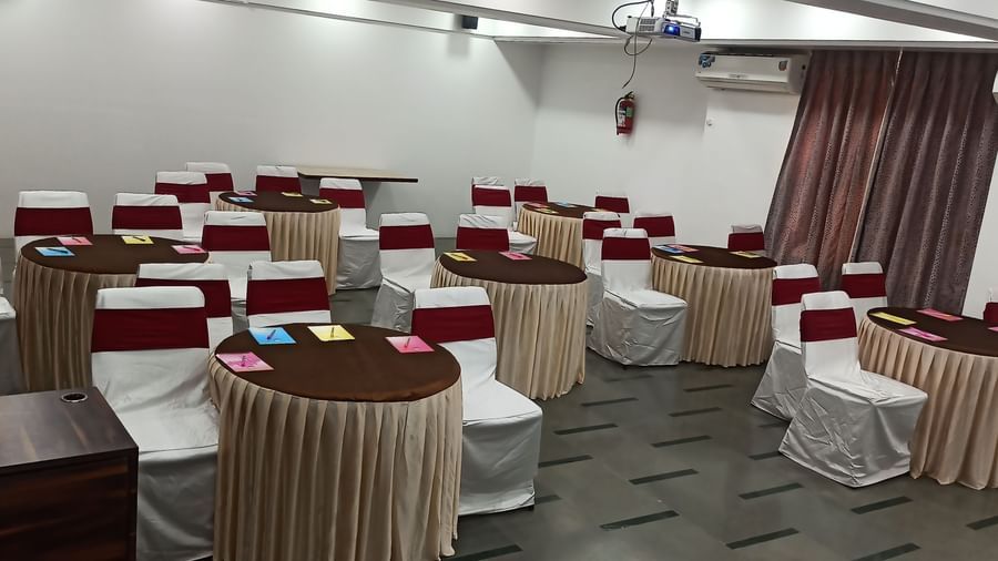 Wide-angle view of a hall at Mayur Retreat with cluster seating arrangement.