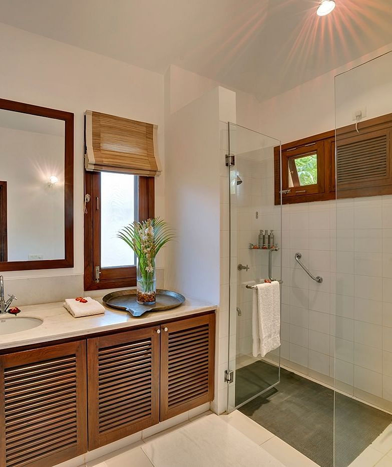 Modern bathroom with a spacious vanity and a clean shower area - Shreyas Retreat